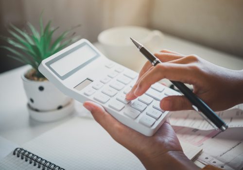business person sitting at a desk at an office By using the calculator to work. Business Concept Analysis and Planning